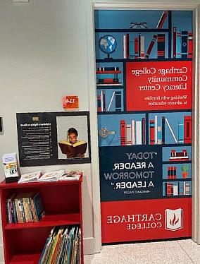 A door with the Carthage College Community Literacy Center logo and a small book shelf with books.